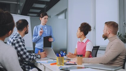 Team gives round of applause to colleague who has just delivered presentation, acknowledging her efforts and success. Positive office environment fosters encouragement and support among coworkers