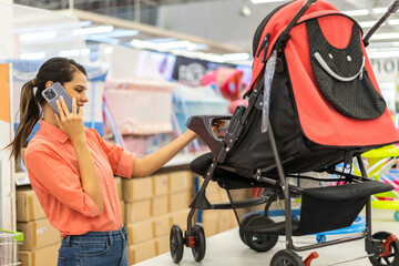 Mother woman carefully examines a modern, decision making stroller in spacious baby store, mindful...