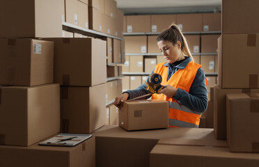Warehouse employee sealing a delivery box