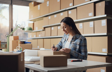 E-commerce owner writing an address on a delivery box