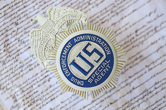 KYIV, UKRAINE - MARCH 9, 2024 US DEA Special Agent badge on United States Constitution close up