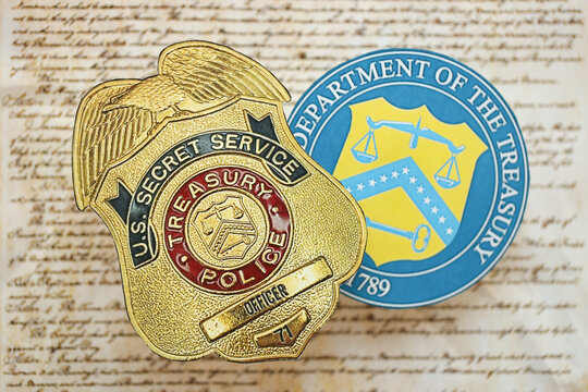 KYIV, UKRAINE - MARCH 9, 2024 US Treasury Police Secret Service Officer badge and Department of Treasury seal on United States Constitution close up