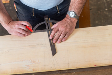 Tischler arbeitet in seiner Werkstatt mit einem Gradmesser Werkzeug