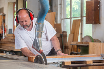 Tischler in seiner Werkstatt arbeitet an der Kreissäge - 756348163