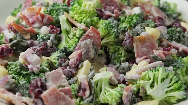 Eating Homemade Broccoli Salad with bacon, red onion, cranberries, pumpkin seeds and cheese