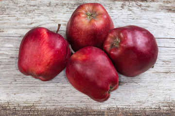 Red apples on an old cracked wooden surface