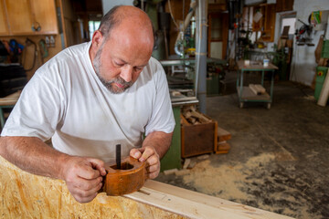 Tischler in seiner Werkstatt arbeitet mit altem Hobel - 756349502