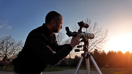 Amateur astronomer observing Sun eclipse and Sun with a telescope and special solar filter. - obrazy, fototapety, plakaty