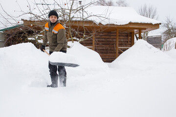 A man removes fallen snow in the courtyard of a house.