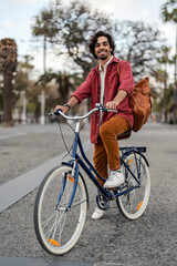 Obraz premium A gen z guy is riding a bicycle on city street downtown.