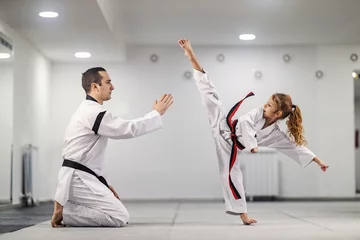 Keuken spatwand met foto A taekwondo girl is practicing kick with trainer at martial art school class. © dusanpetkovic1