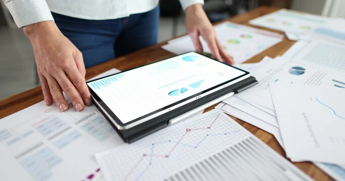 Business woman using a tablet computer and statistical charts conducts audit. Innovative technology business and finance concept
