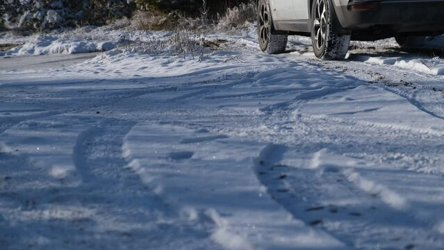 Wheel car winter close-up. The car drives along a winter rolling road. Shooting from a lower angle. The concept of winter selection and advertising of winter tires. traveling by car, adventures