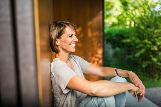 gl&uuml;ckliche Frau in der Sonne vor ihrer neuen Immobilie, Bayern, Deutschland