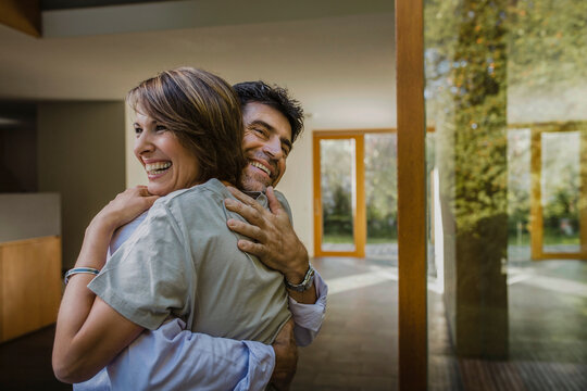 gl&uuml;ckliches Paar schaut aus dem Fenster einer neuen Immobilie, Bayern, Deutschland