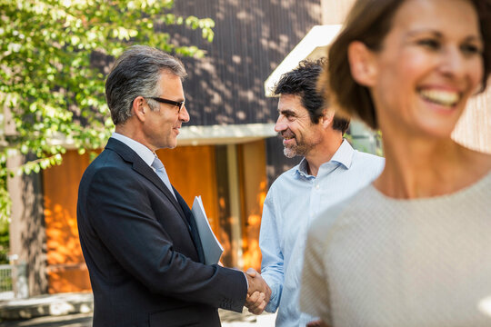 Paar mit Immobilienmakler Schl&uuml;ssel&uuml;bergabe einer neuen Immobilie, Bayern, Deutschland