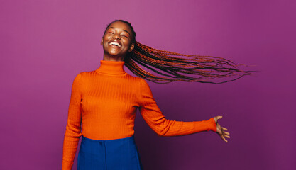 Confident gen z woman with two tone braids celebrating on a vibrant colored background - 756361152