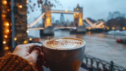 Keuken foto achterwand Tower Bridge Close-up of a female hand holding a cup of coffee and Tower Bridge  is in the background, first-person photo, blurred background, travel image with well known destination