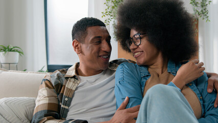 African American happy family couple in love affection bonding talking communicate talk conversation casual speaking smiling discuss share news boyfriend man and girlfriend woman at home couch sofa