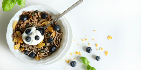 Cereali da colazione integrali, mirtilli e yogurt isolati su sfondo bianco. Cibo salutare. Copia...