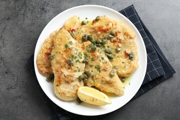 Delicious chicken piccata with herbs on grey table, top view