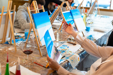 Art and Wine workshop. Closeup of girl's hand with paintbrush