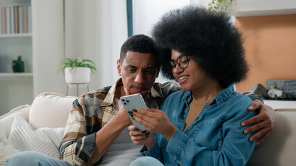 African American spouses couple man woman girl guy on sofa couch at home together talk discuss...