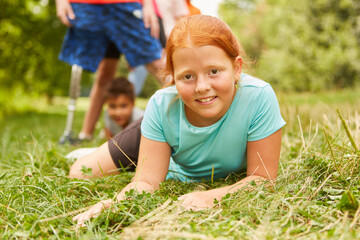 Redhead girl lying on grass at park