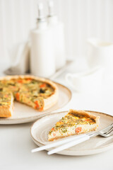 French quiche lauren with salmon, cheese and broccoli on white table. Soft focus