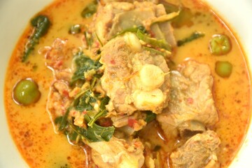 boiled pork bone with basil and chili in coconut milk curry soup on bowl