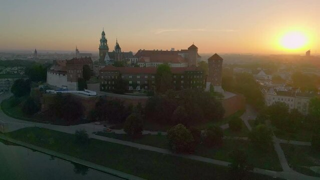Drone circles Wawel Castle in Krakow, Poland during a spectacular summer sunrise. The old town is in the background