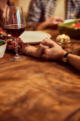 Close-up of two female hands, praying before the dinner, holding hands. - 756408725