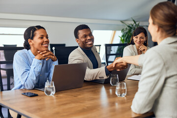 Businesspeople starting a meeting with some other clients, doing a handshake. - 756408735