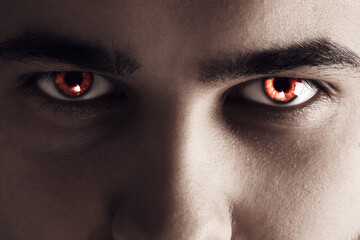 Evil eye. Man with red demonic eyes, closeup