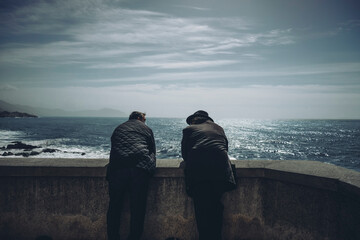 Two people on a wall, admiring the ocean landscape and horizon