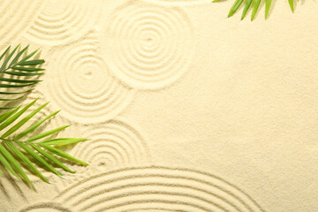 Zen rock garden. Circle patterns and green leaves on beige sand, top view