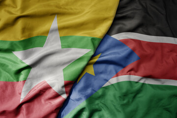 big waving national colorful flag of south sudan and national flag of myanmar .