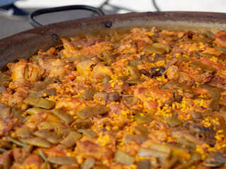 Close-up of a Valencian paella, made in a traditional way, with rice, chicken, rabbit and green beans, made in a paella pan