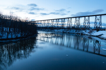 Blue hour view of the 1908 railway trestle bridge over the Cap-Rouge River seen during a winter...