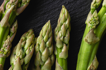 Green asparagus on a black background with copy space