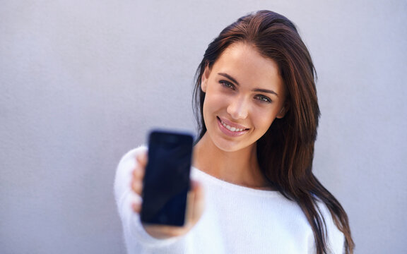 Portrait, woman and smartphone with screen in studio for connectivity, communication and mobile with technology. Female person, cellphone and chatting or texting in gray background for conversation