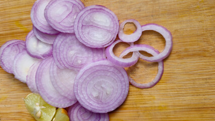 Obraz na płótnie Canvas Top angle shot of Sliced Onion with lemon on wooden surface.