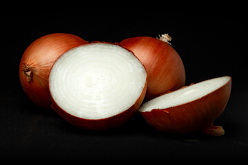 Fotografía de estudio de varias cebollas blancas aisladas sobre un fondo liso negro