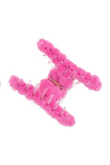 Close-up shot of a pink fluffy hair clip. Open hair claw clip, decorated with a heart is isolated on a white background. Top view. A fashionable hair accessory with fur.