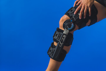 closeup shot of a knee brace with angle movement controler on a leg, medical concept. High quality...