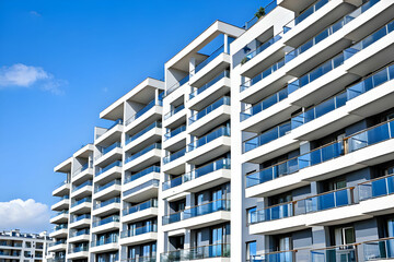 New block of modern apartments with balconies and blue sky in the background. Modern building