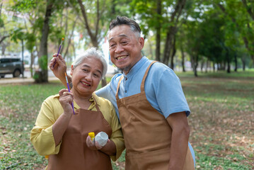 Elderly men and women doing activities in the park Use a paintbrush to paint pottery. Learn the art of treating depression. The concept of depression in the elderly