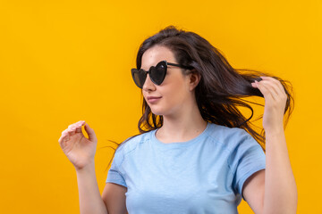 Woman wearing heart shape sunglasses arranging her hair