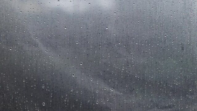 Raindrops on transparent oilcloth. Many drops of water on a transparent background. Condensation in the greenhouse, high humidity