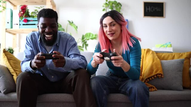 Couple Enjoying Competitive Gaming Session at Home. Intense couple playing video games, focused and competitive in a cozy home setting.